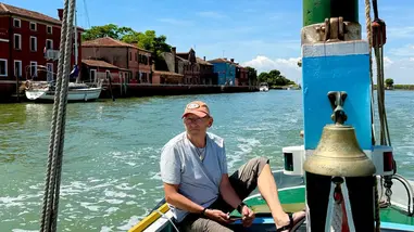 Captain Mike, owner of Around Venice Tours, at the rudder of Stella, a classic 1965 Bragozzo boat.
